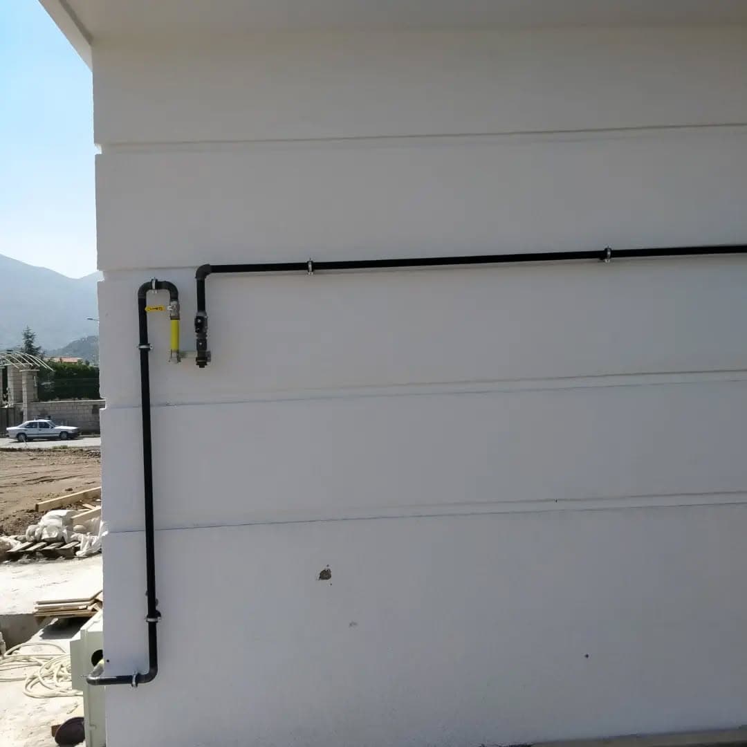Bina dış cephesinde döşenmiş siyah doğalgaz hattı ve vana